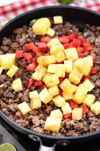 ground beef pineapple and chopped bell peppers in a pan