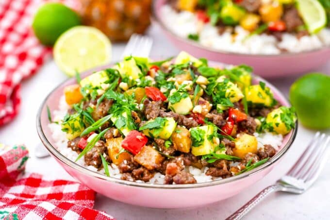 a pink bowl of pineapple ground beef topped with cilantro