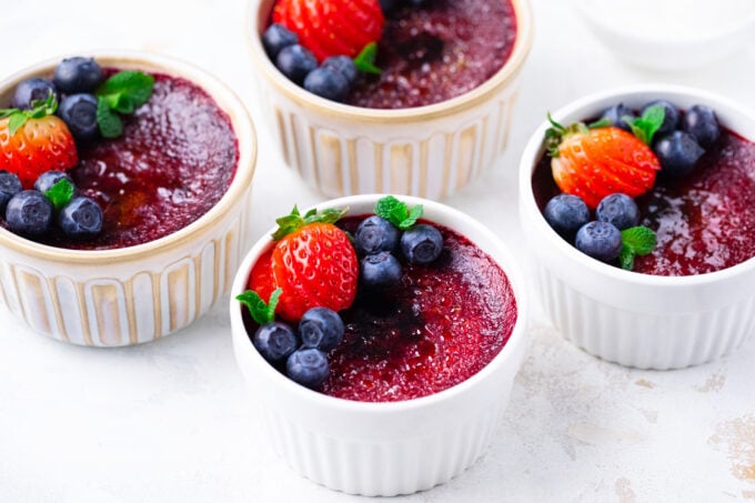Ramekins with red velvet creme brulee topped with berries.
