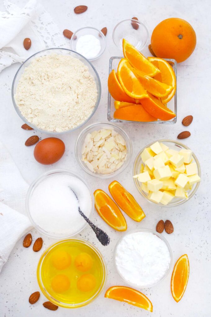 overhead shot of ingredients for almond orange cake arranged in bowls on a table