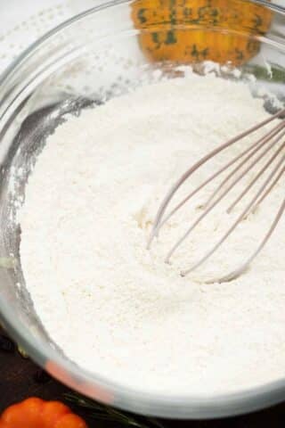 mixing flour with a whisk in a large bowl