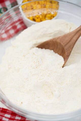 a bowl with flour with a wooden spoon in it