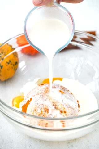 pouring cream in a bowl with pumpkin puree