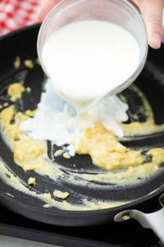 pouring cream into a roux in a skillet