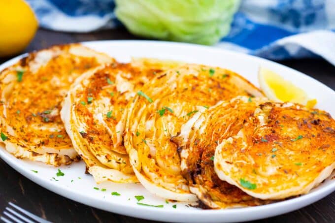 A serving plate of perfectly cooked air fryer cabbage steaks.