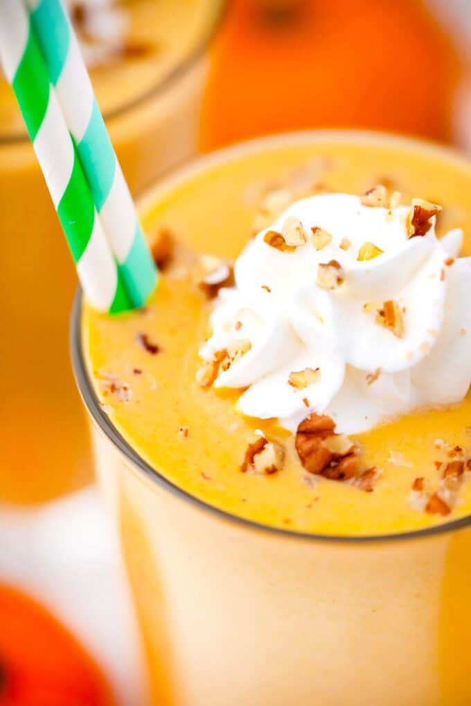 close shot of vegan pumpkin pie smoothie with whipped cream