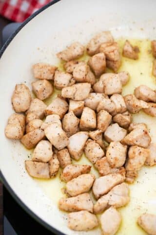 sautéing chopped chicken breast in a skillet