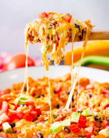 a cheesy spoonful of chicken burrito skillet pulling strings of cheese up