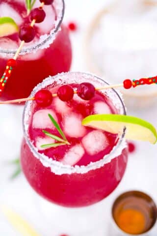 overhead shot of cranberry margarita with rosemary and lime