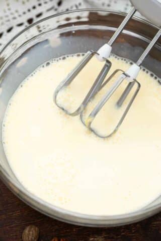 milk and egg mixture in a bowl with an electric mixer