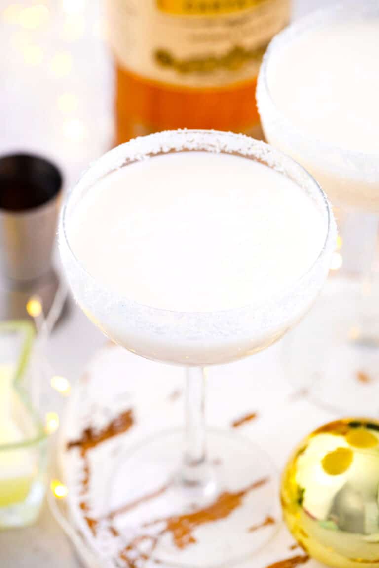 overhead show of white creamy snowflake martini with coconut glass rim