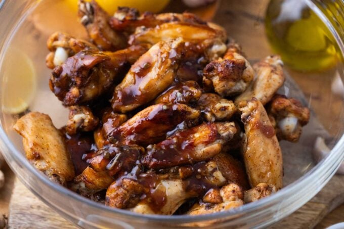 tossing oven baked wings with honey garlic sauce