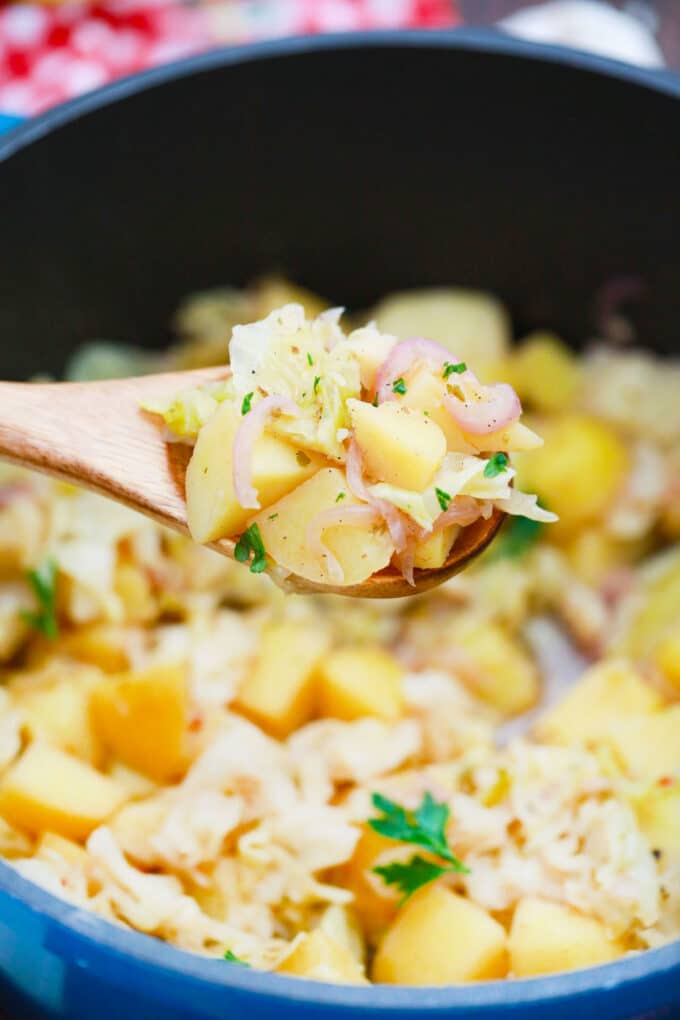 A serving spoon of smoked cabbage and potatoes.