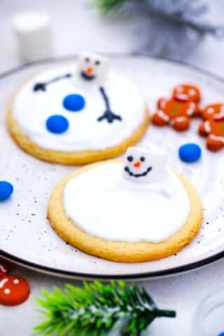 two melted snowman cookies on a plate