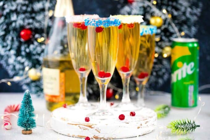 four festive champagne cocktails with sprinkle and buttercream covered rims