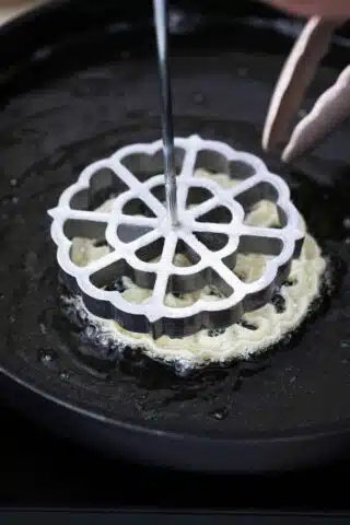 frying a rosette flower shaped cookie