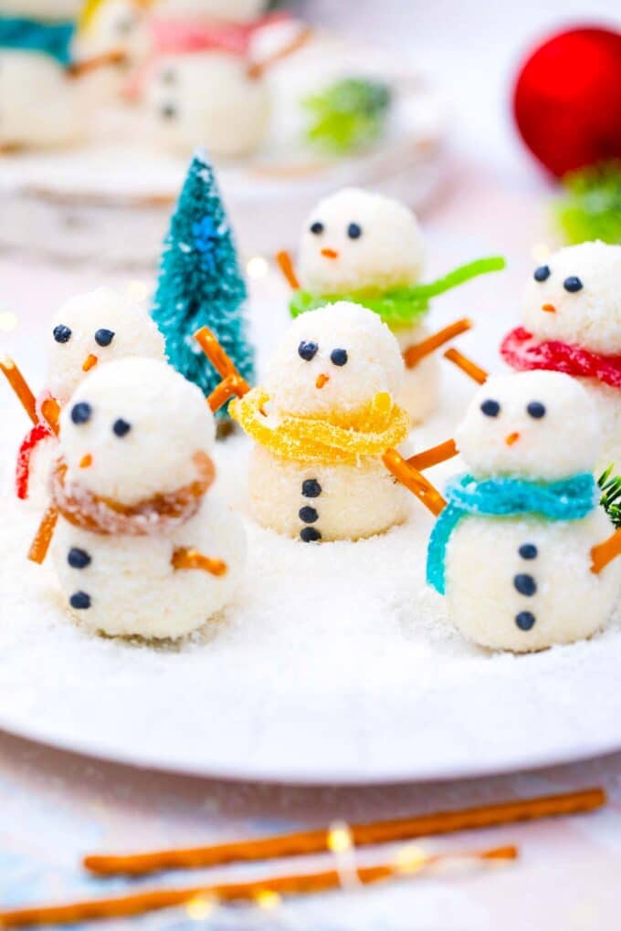 no bake snowman truffles on a plate with shredded coconut