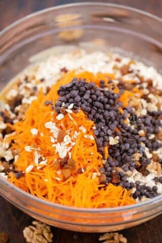 shredded carrot and chocolate chips in a bowl with oatmeal cookie dough mixture