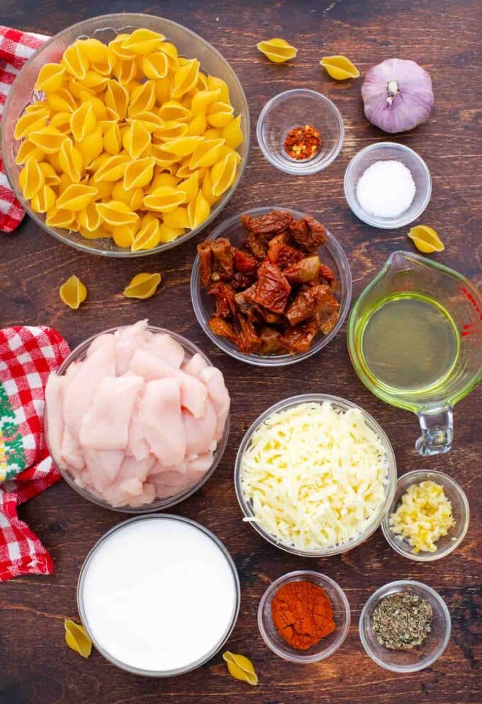 overhead shot of chicken mozzarella pasta ingredients in bowls on a table