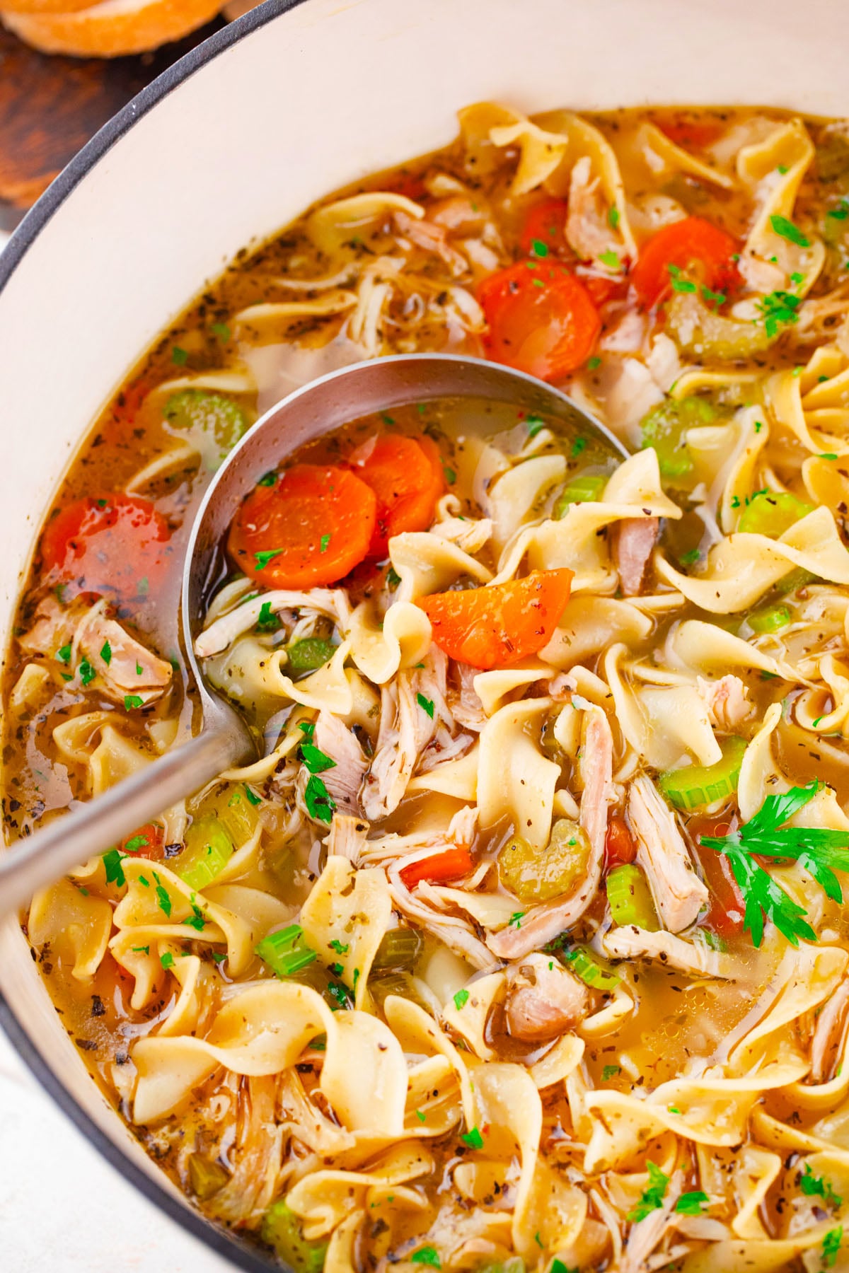 A ladle of classic homemade chicken noodle soup.