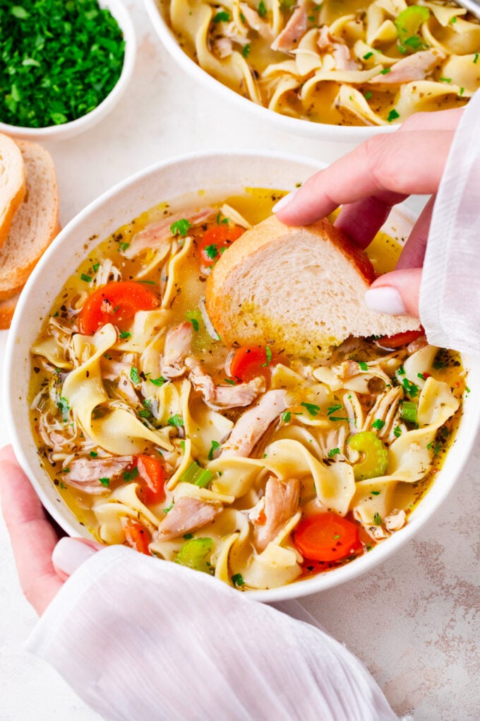 Dipping bread in homemade chicken noodle soup.