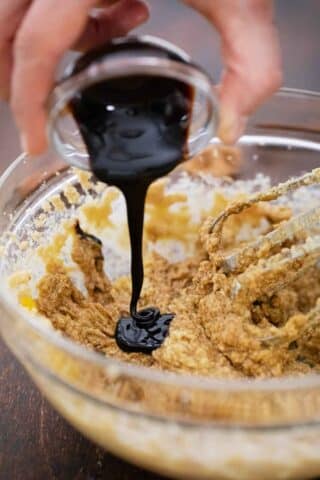 adding molasses to a bowl with butter and brown sugar