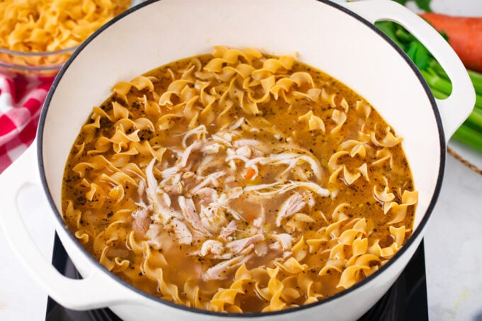 Adding egg noodles to chicken noodle soup.