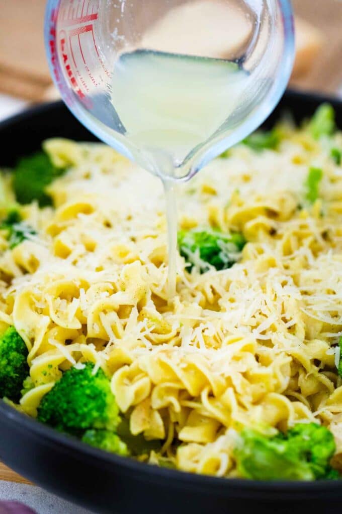 adding lemon juice to lemon broccoli pasta