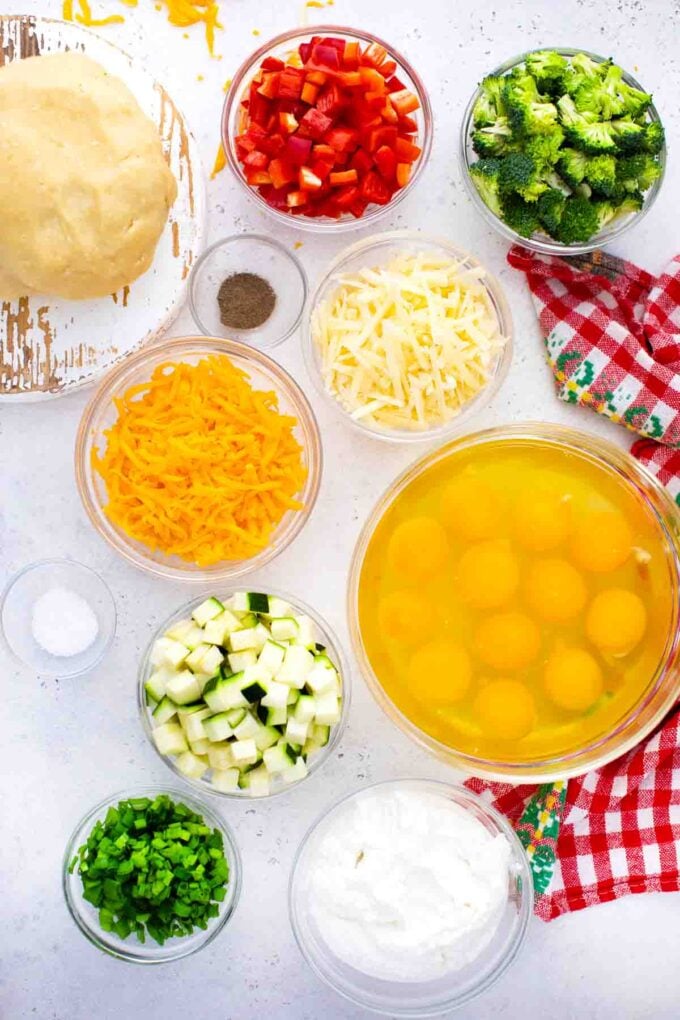 overhead shot of sheet pan quiche ingredients in bowls on a table