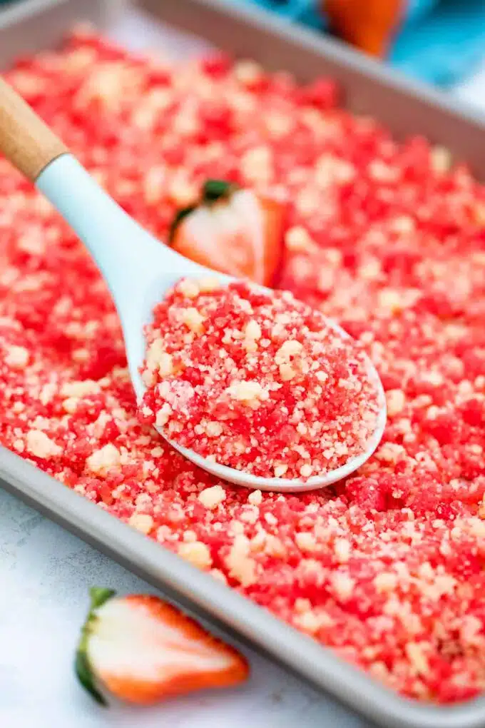 a spoonful of strawberry shortcake crumbs on a baking sheet