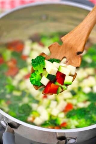 close shot of sauteed veggies on a wooden spoon