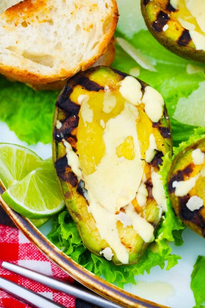 grilled avocado on salad green with lime on the side