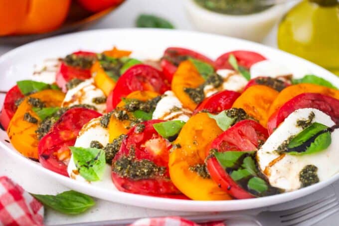 caprese salad with sliced orange and red heirloom tomatoes