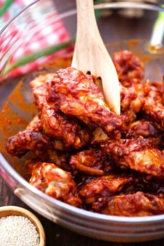 coating chicken wings in a spicy red Korean sauce