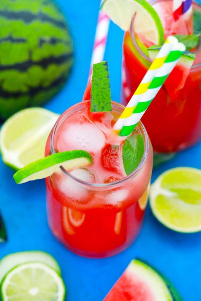 Homemade boozy watermelon lemonade over ice cubes in tall glasses.