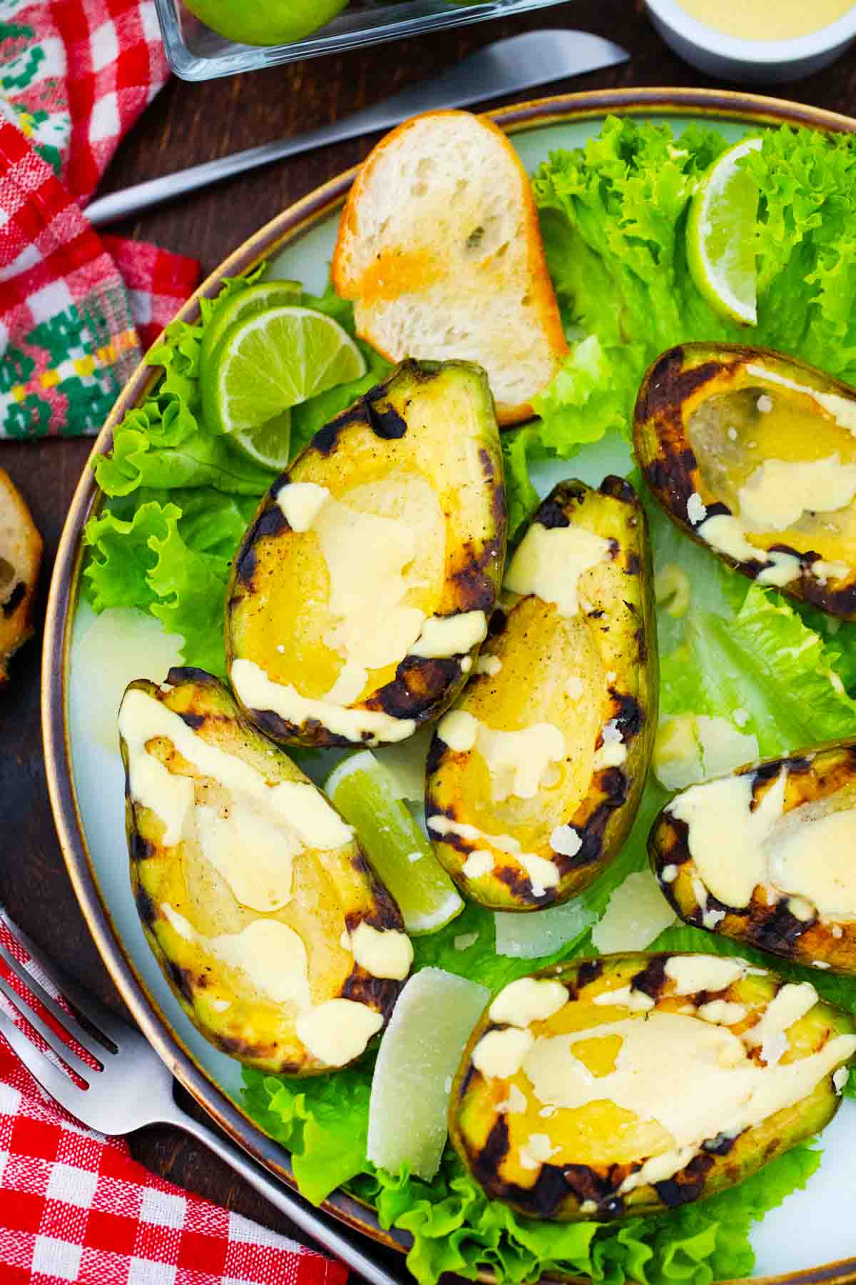 overhead shot of grilled avocado on a plate with salad greens