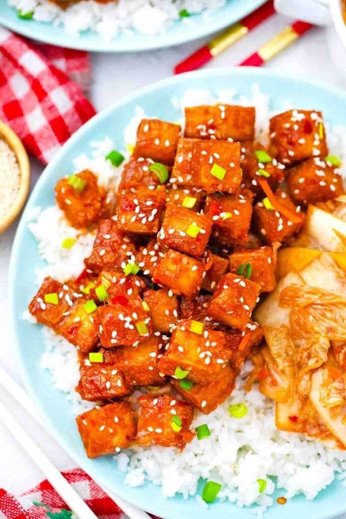 overhead shot of a plate of spicy korean tofu over rice with kimchi