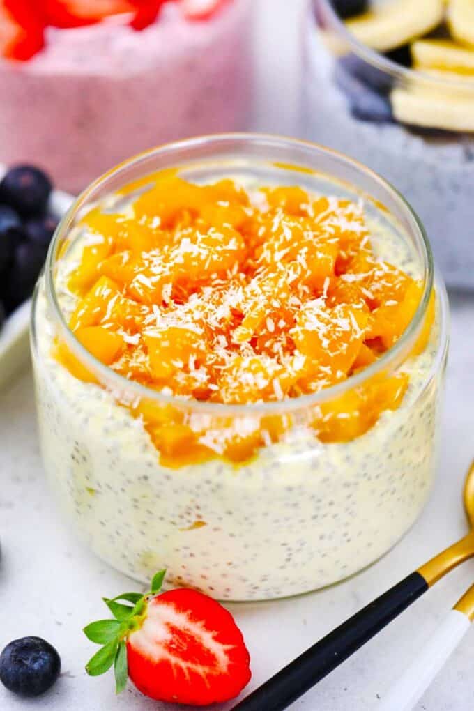 mango cheesecake chia pudding topped with chopped mango and shredded coconut