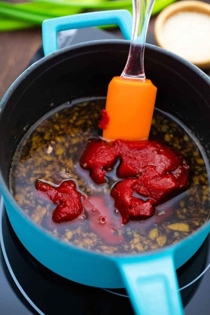 stirring Korean Gochujang into a sauce pan