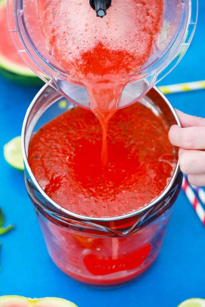 Straining watermelon and cucumber mixture.
