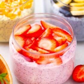 strawberry cheesecake chia pudding topped with fresh sliced strawberries