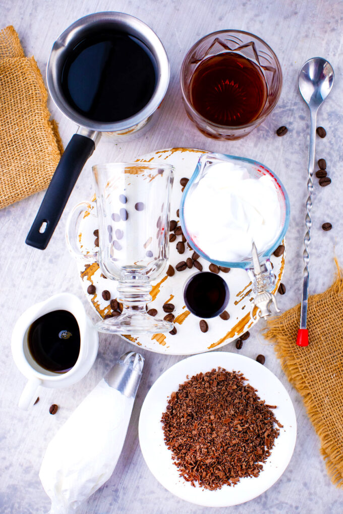 Overhead shot of Irish coffee ingredients in bowls on a wooden table.