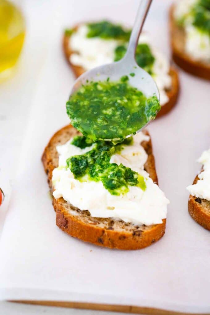 pouring pesto on top of burrata cheese