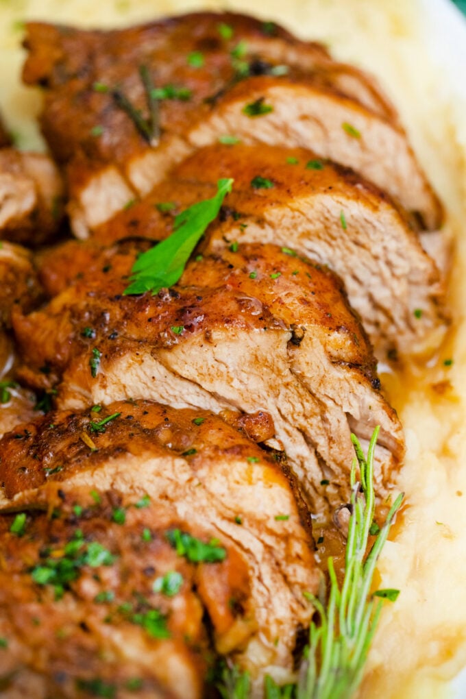 Sliced juicy balsamic pork tenderloin over mashed potatoes.