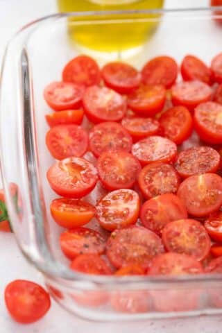 halved grape tomatoes in a roaasting pan