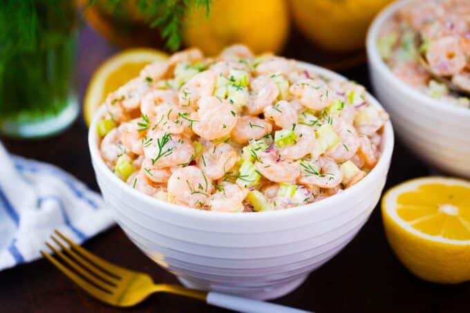 a bowl of shrimp salad topped with fresh dill