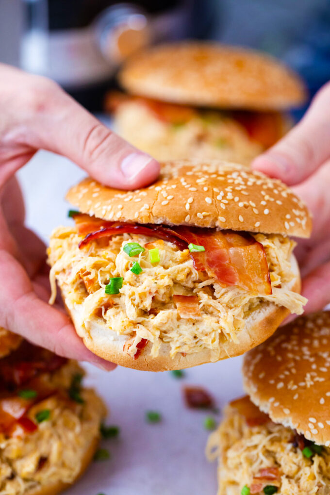 Hands holding a Instant Pot crack chicken sandwich.