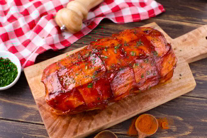 Overhead shot of bacon wrapped meatloaf on a cutting board.