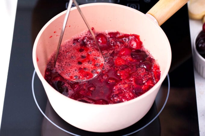 Making cherry puree sauce in a sauce pan.