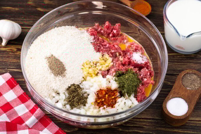 Mixing meatloaf ingredients in a bowl.
